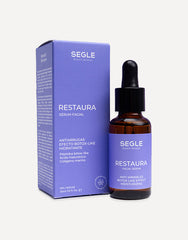 Frasco de sérum con pipeta, envase de vidrio ámbar y etiqueta minimalista sobre fondo de color azul.